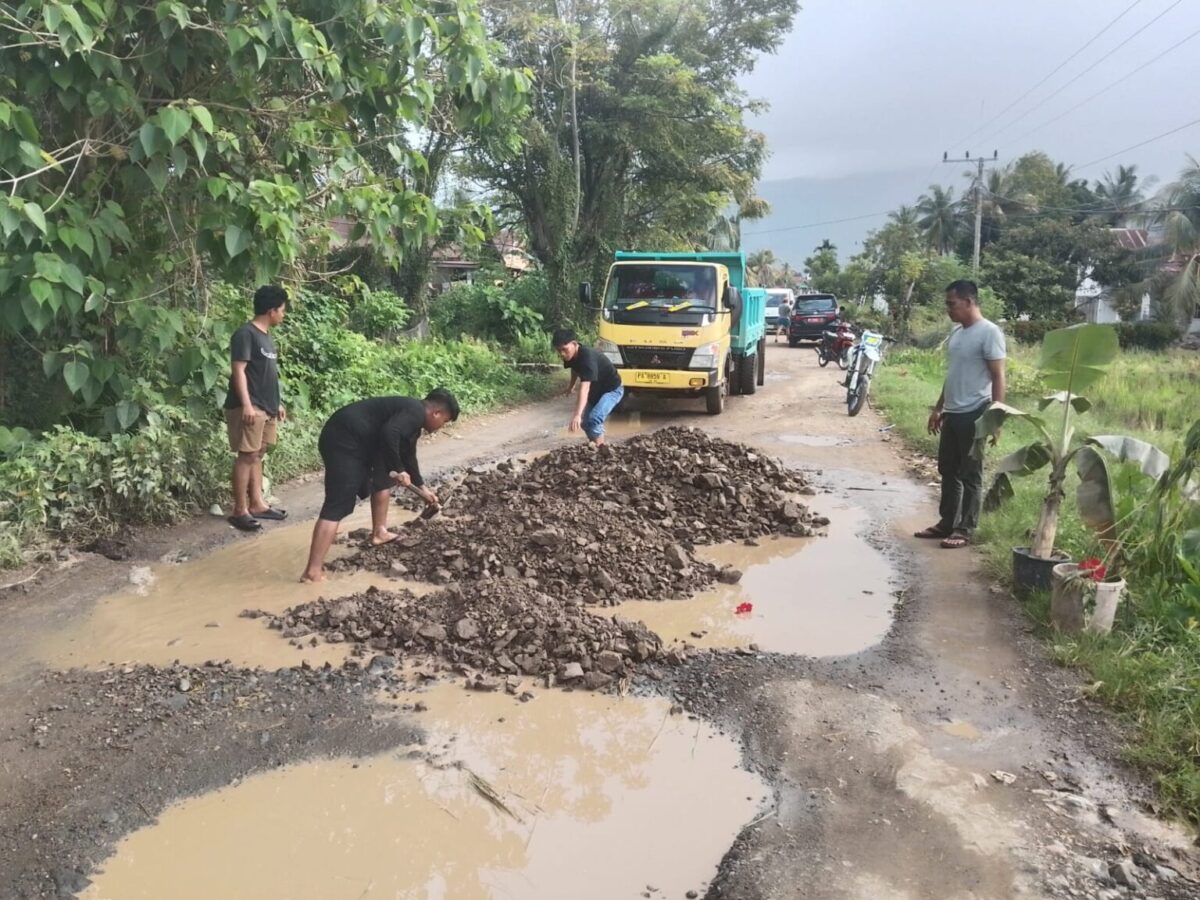 Sejumlah warga setempat memperbaiki jalan tersebut